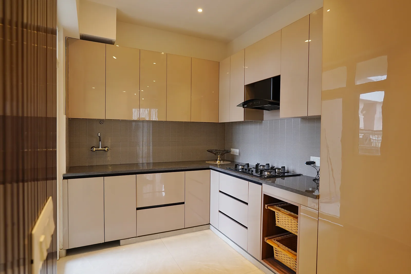 Modular kitchen in an AIGIN Royal 3 BHK apartment with granite counter and chimney