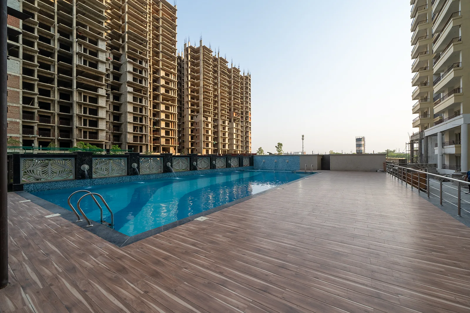 Swimming pool and wooden sun deck at AIGIN Royal with residential towers behind