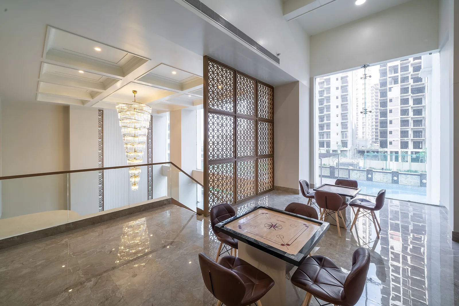 Double-height living area of an AIGIN Royal 4 BHK duplex with chandelier and mezzanine