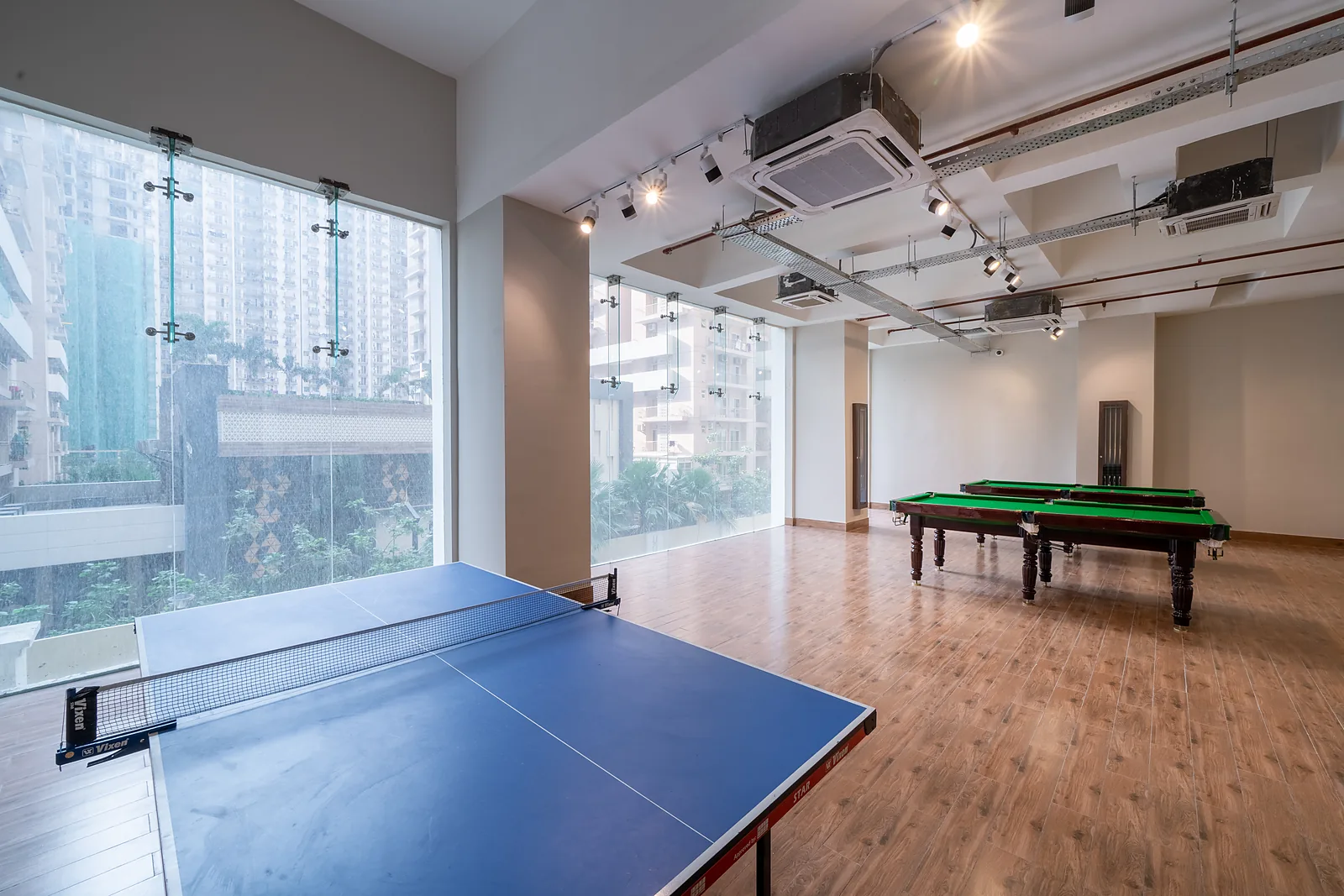 Indoor games room at AIGIN Royal with table tennis and billiards tables